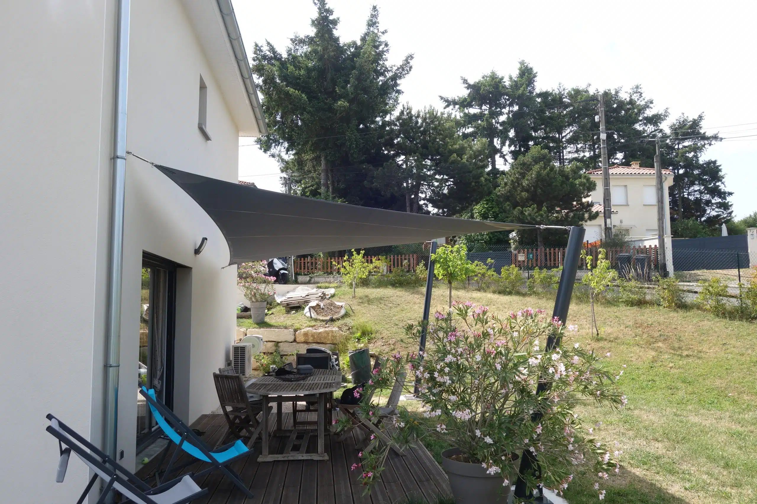 Voile d'ombrage, fixée au mur et aux deux mâts inclinés, réalisés sur-mesure.