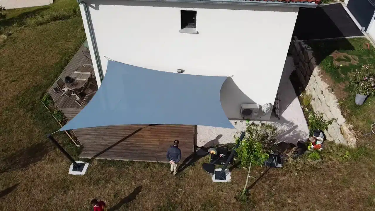 Vue aérienne de la terrasse : la voile d'ombrage est fixée aux mâts inclinés