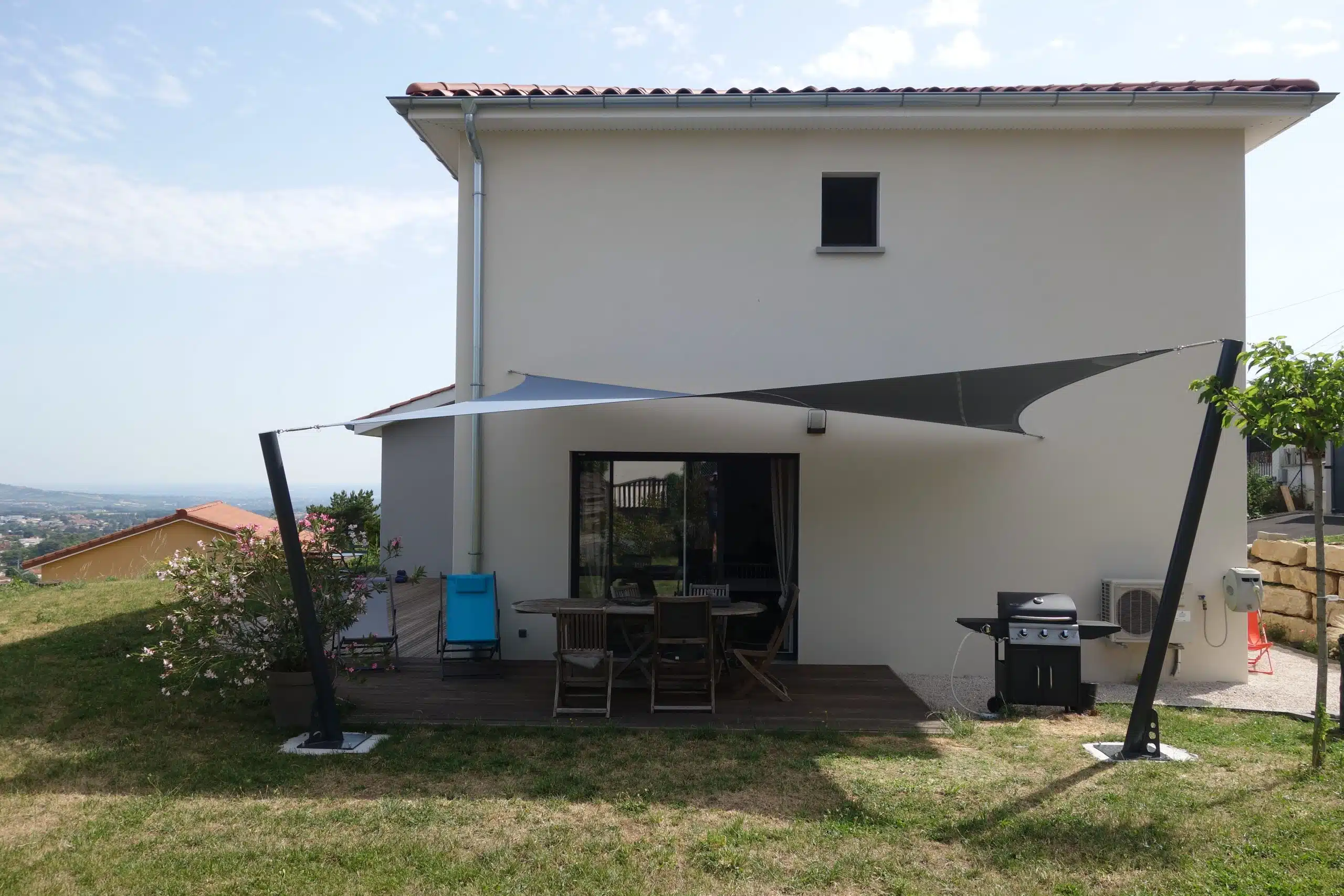 Terrasse abritée (69) : belle voile d'ombrage vrillée, fixée aux mâts sur-mesure
