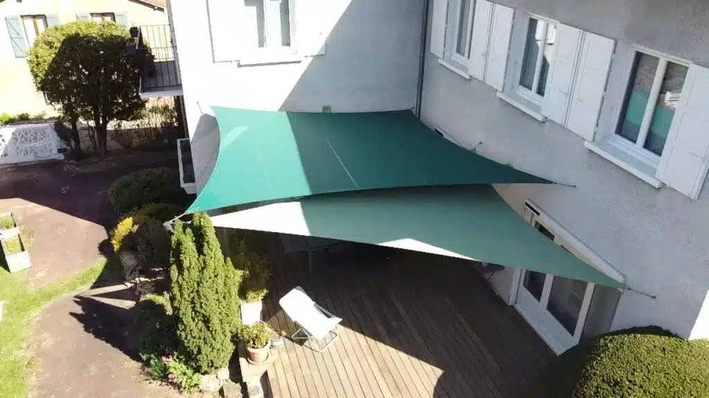 Deux voiles d’ombrage vertes en toile Soltis 92 créant un espace ombragé sur une terrasse à Lyon