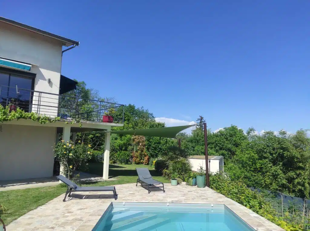 Voile d’ombrage verte en toile Soltis 92 couvrant une terrasse et un jardin à Neyron