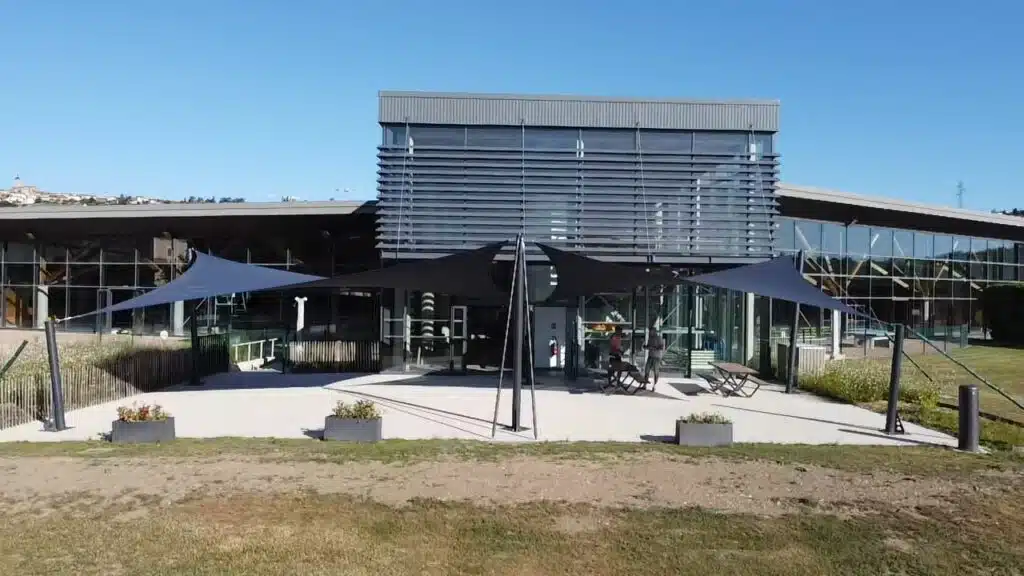 Voiles d’ombrage en toile Australe gris anthracite installées sur la terrasse du centre nautique de Genilac (42)
